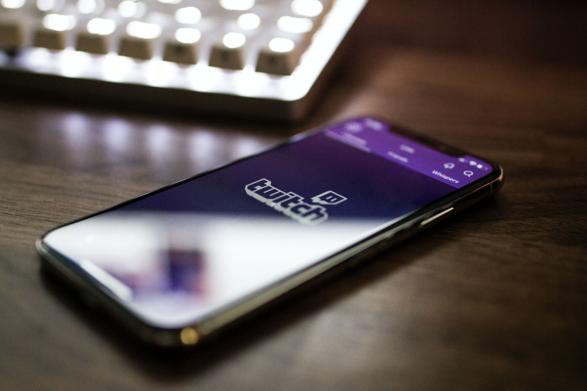 Téléphone affichant l'application Twitch posé sur un bureau